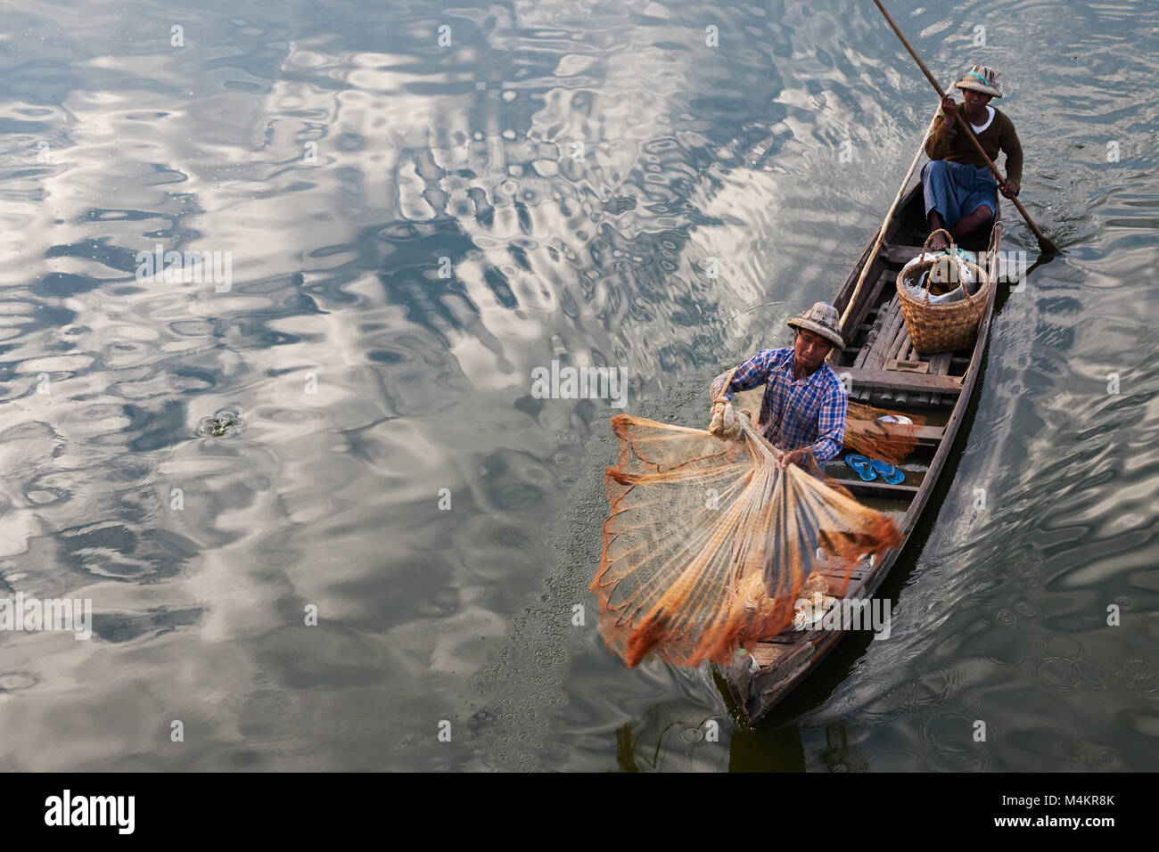 Fischer, die mit Fischen net Fisch bei TaugThaMan See unterhalb U-Bein Brücke in Amarapura, in der Nähe von Mandalay, Myanmar, Birma zu fangen. Stockfoto