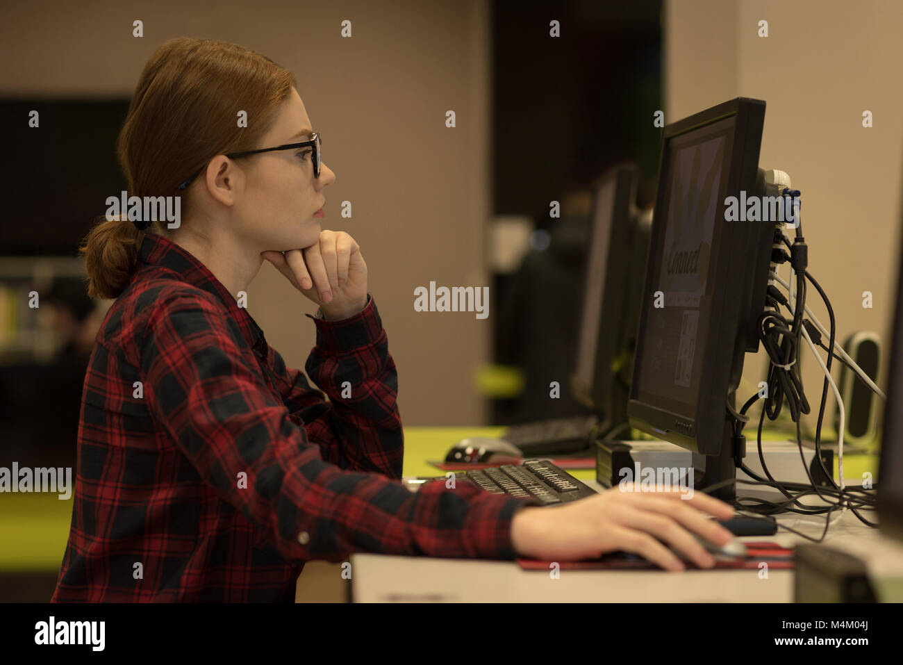 Junge Frau mit einem Desktop-PC Stockfoto