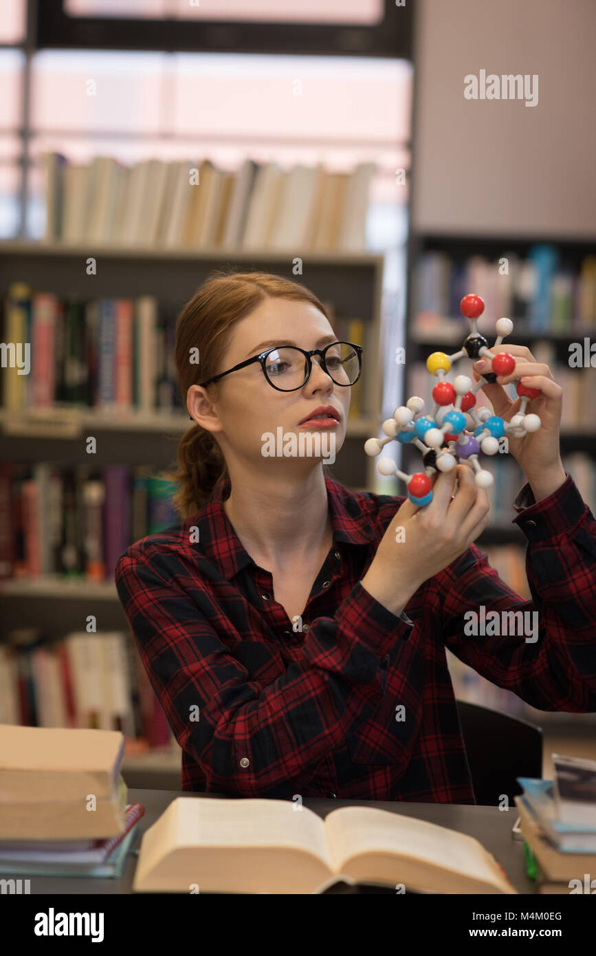Junge Frau Analyse eines Moleküls Modell Stockfoto
