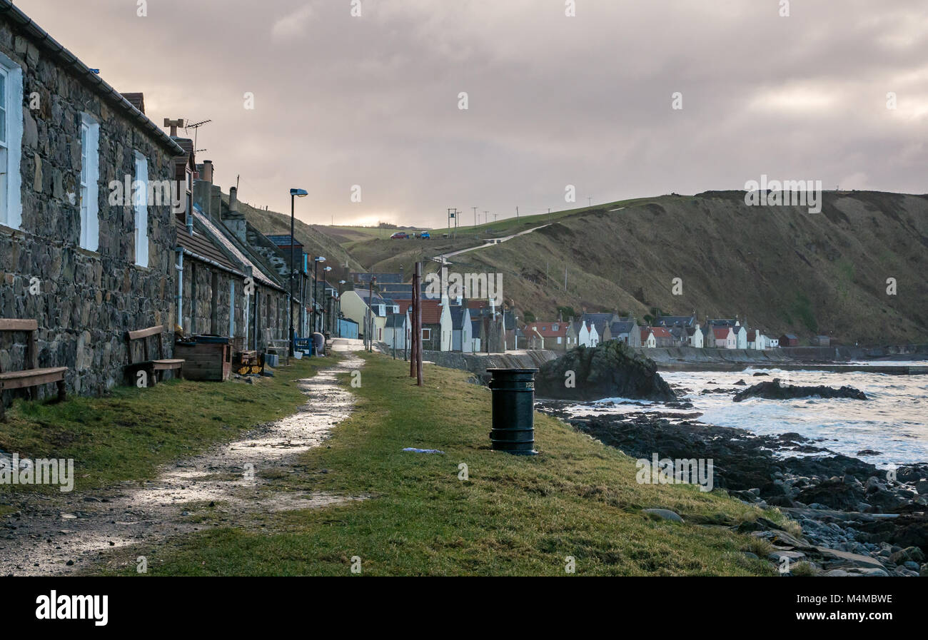 Ausblick auf den kleinen Küstenort Crovie, Aberdeenshire, Schottland, Großbritannien, mit Gable End Cottages am Ufer vorne Stockfoto