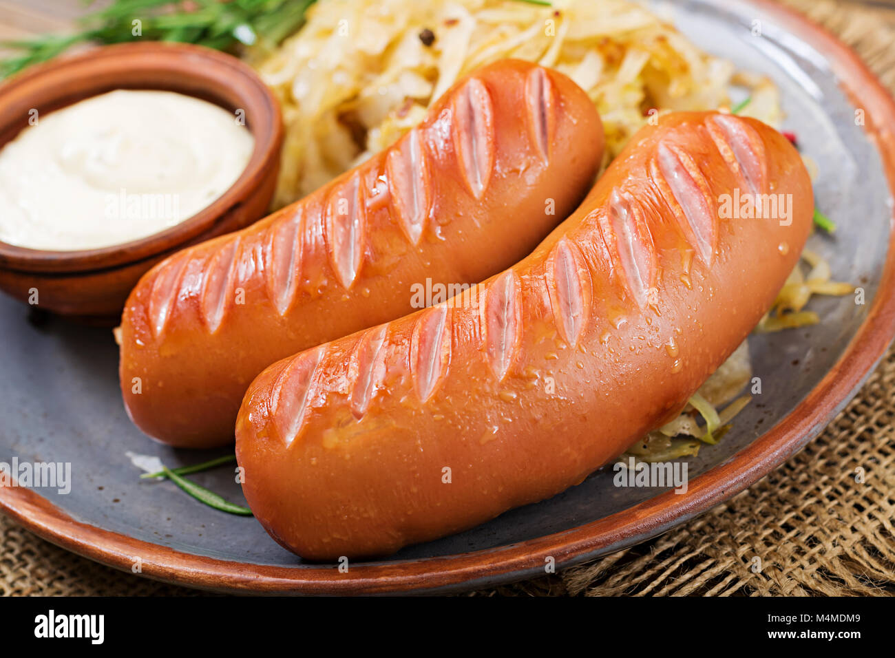 Platte mit Wurst und Sauerkraut auf hölzernen Tisch. Traditionelle Oktoberfest Menü Stockfoto