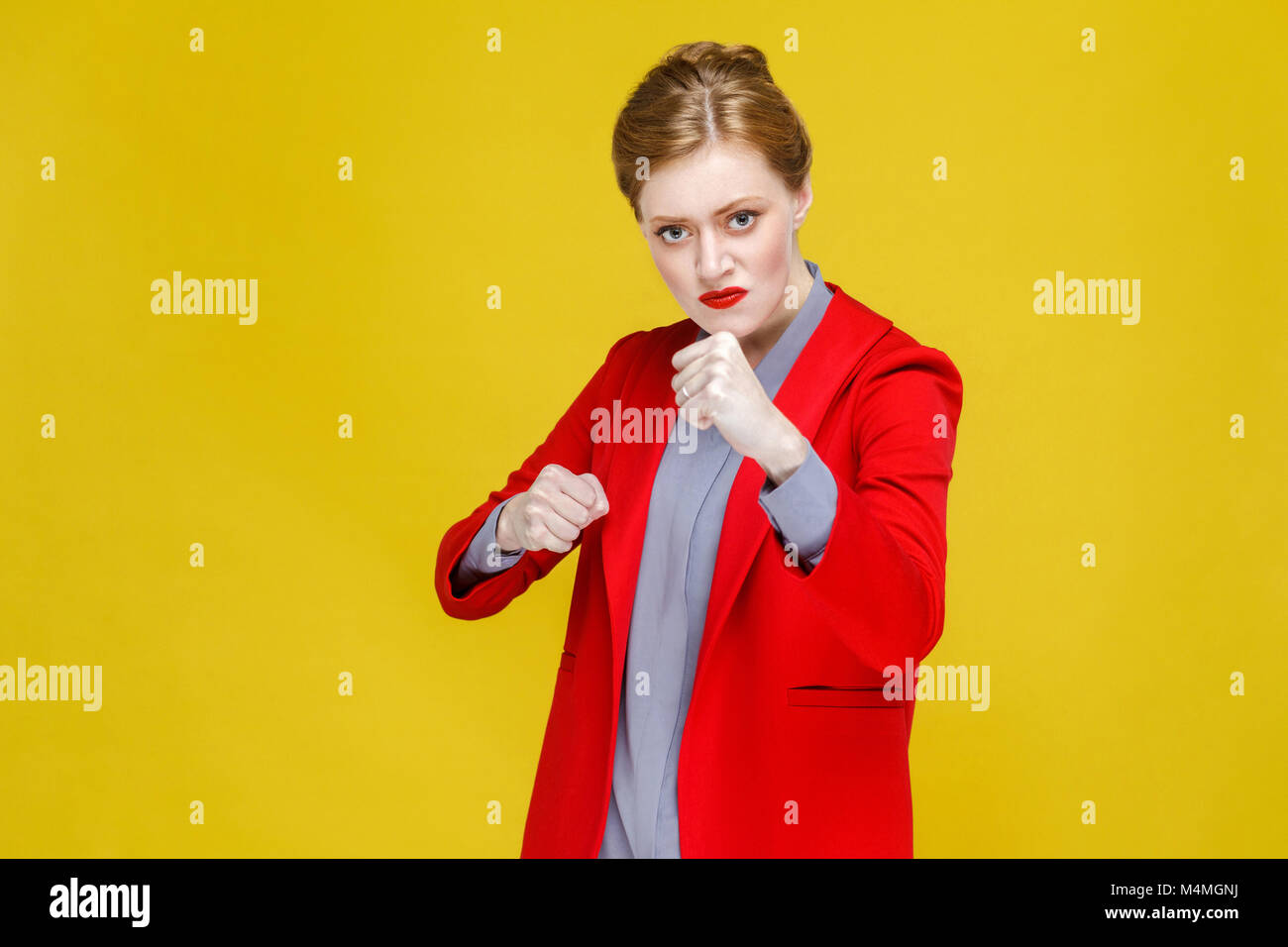 Aggressiv wütend Mode Frau in Anzug Boxen an der Kamera. Studio shot, auf gelbem Hintergrund Stockfoto