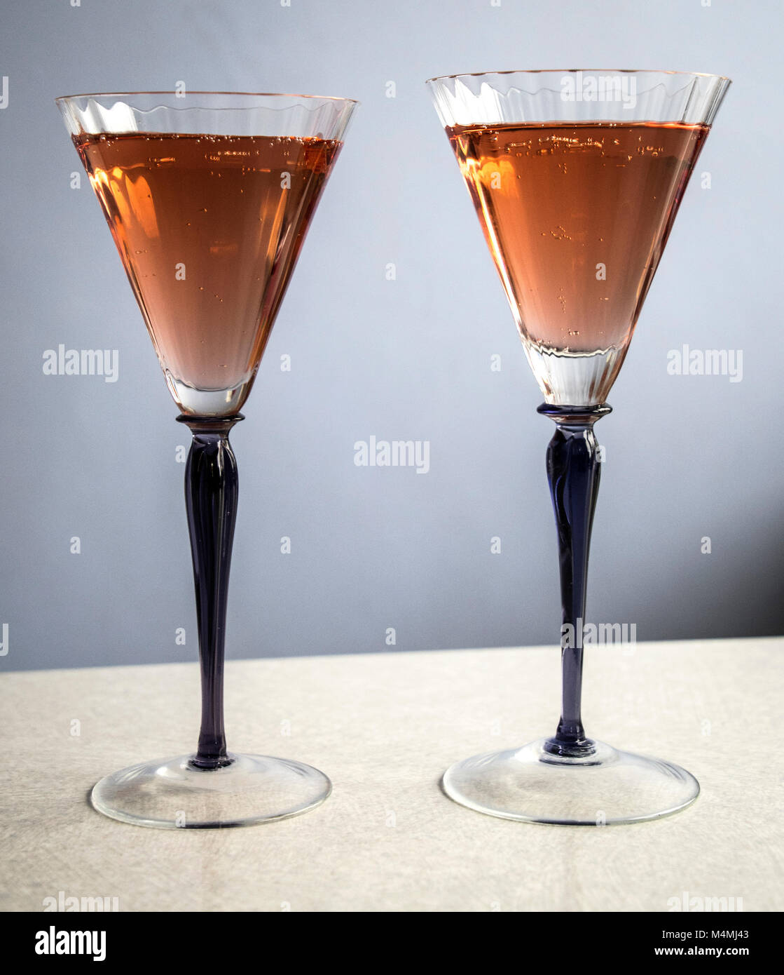 Zwei Gläser, Violett mit rosa Champagner auf hellen Hintergrund stammt Stockfoto