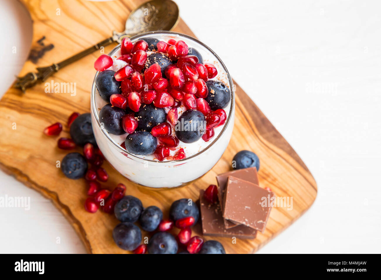 Tiramisu in ein Glas mit mascarponecreme, Blaubeeren und Granatapfel Obst,  süße Tasse Dessert auf Holzbrett Stockfotografie - Alamy