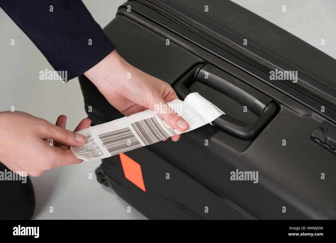 Fluglinie Gepäck Sicherheit Tag zu einem Reisenden schwarze Koffer befestigt werden Stockfoto