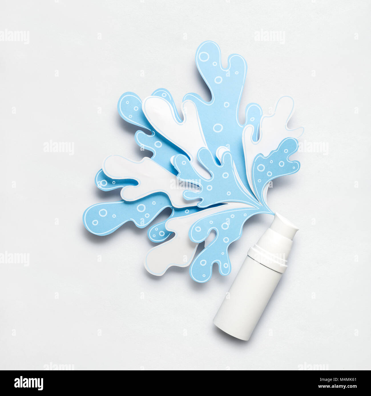 Kreatives Konzept Foto von kosmetischen Flasche mit spritzenden Flüssigkeiten aus Papier auf weißem Hintergrund. Stockfoto