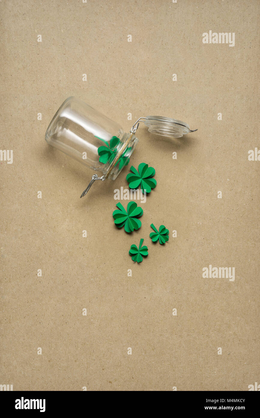 Kreative St. Patricks Tag Konzept Foto von einer Flasche mit Shamrocks aus Papier auf braunem Hintergrund. Stockfoto