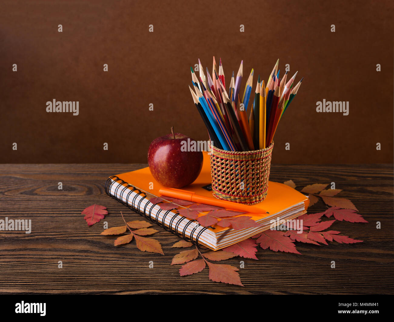 Bunte Bleistifte, Apple und trockenen Herbst Blätter auf Holztisch. Stockfoto