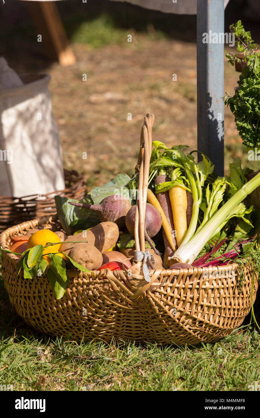 Weidenkorb von frischem Gemüse auf dem Boden vor der Tür. Stockfoto