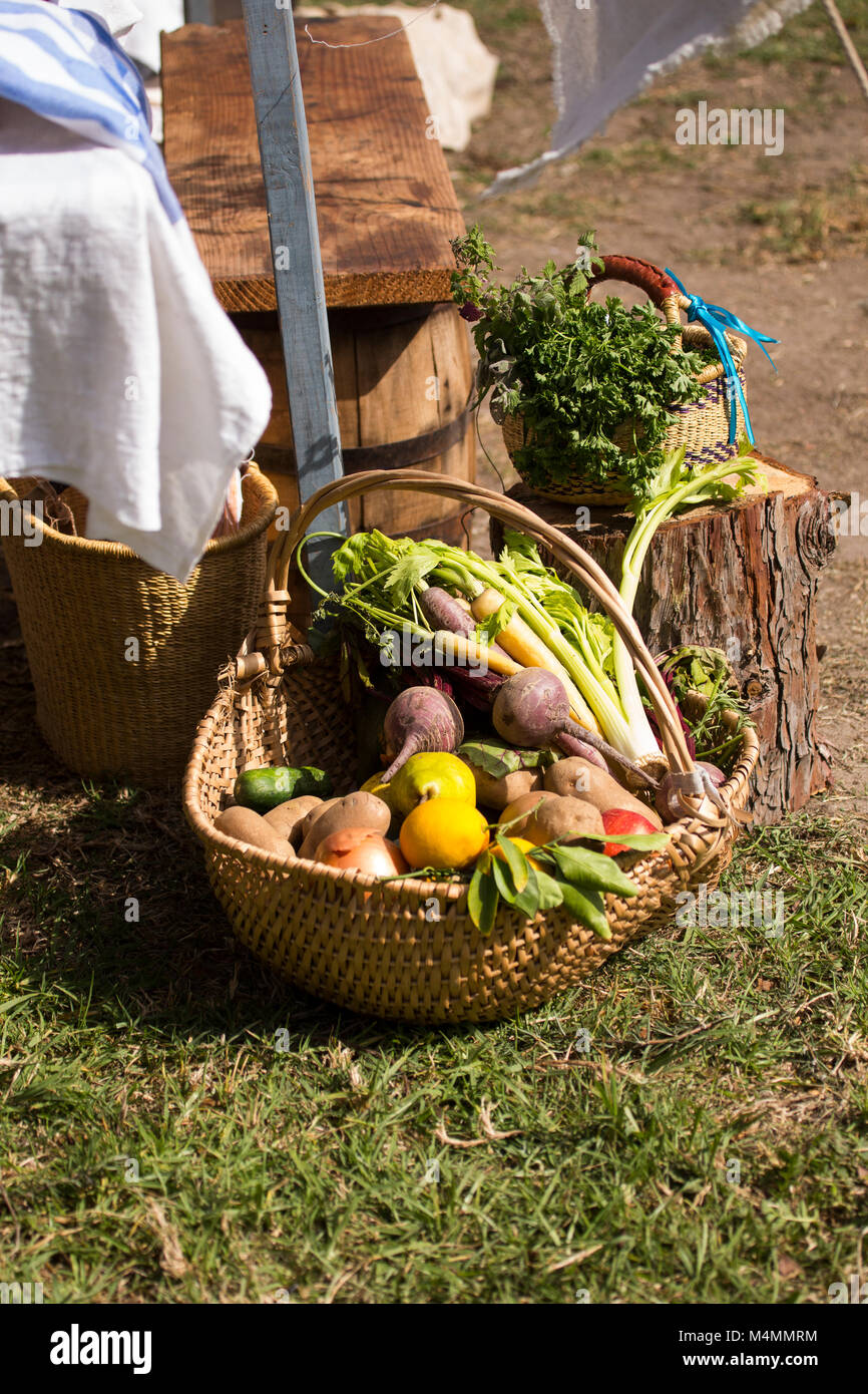 Weidenkorb von frischem Gemüse auf dem Boden vor der Tür. Stockfoto