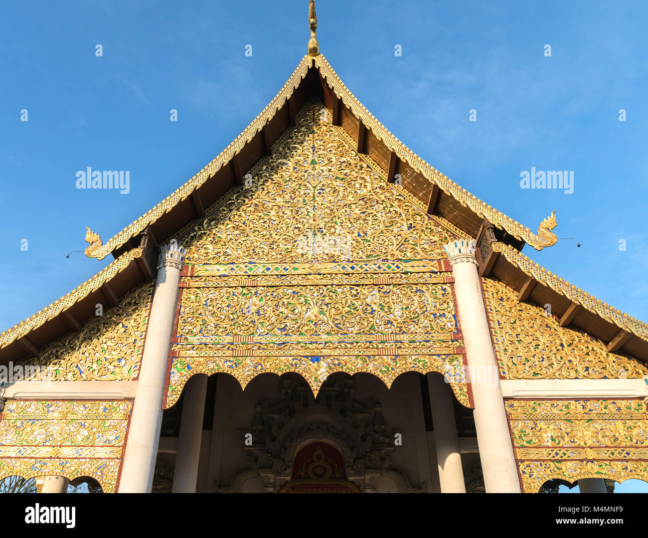 Traditionelle asiatische architektonisches Detail verzierte Fassade der thailändischen buddhistischen Tempel mit geschwungenen Dachlinie und kurvig stenciled Faszie und künstlerischen vergoldeten Giebel Stockfoto