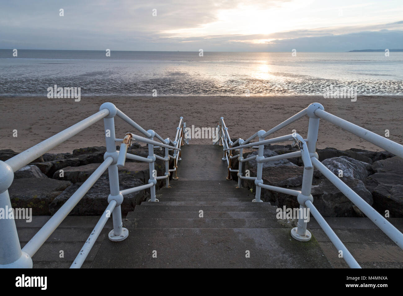 Abendlicht am Strand von Aberavon in South Wales, shwoing Geländer hinunter zum Strand. Stockfoto