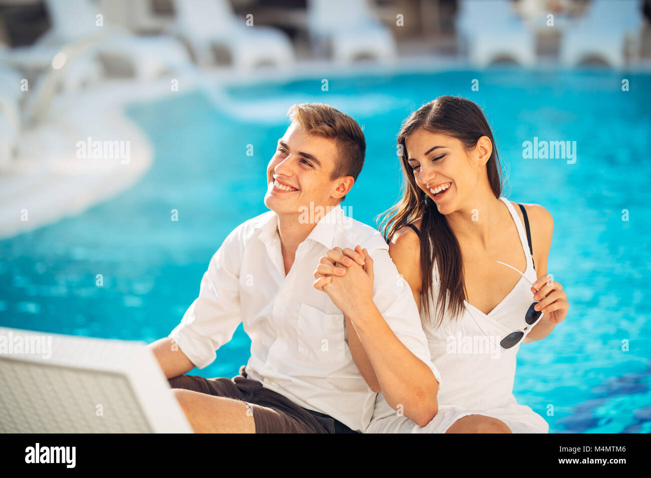 Positiv glückliches Paar entspannend am Pool der Luxus Sommer Vacation Resort. Genießt die Zeit zusammen in Spa Wellness Center. Beziehung succes Stockfoto