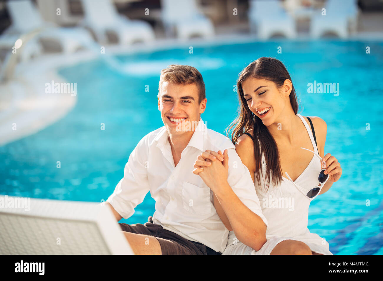 Positiv glückliches Paar entspannend am Pool der Luxus Sommer Vacation Resort. Genießt die Zeit zusammen in Spa Wellness Center. Beziehung succes Stockfoto