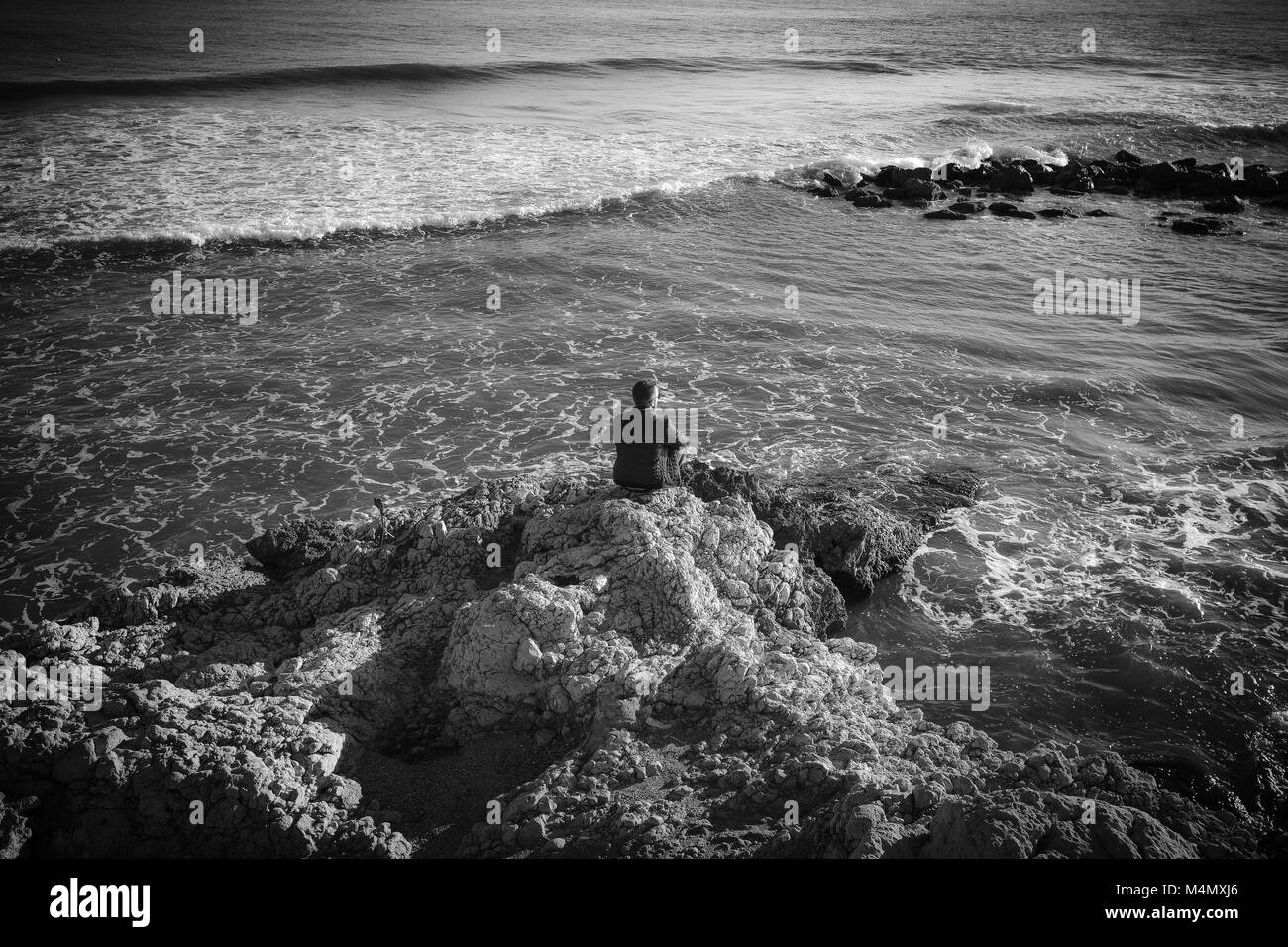 Mann allein Uhren das Meer an der mediterranen Dorfes von Sitges in Spanien. Stockfoto
