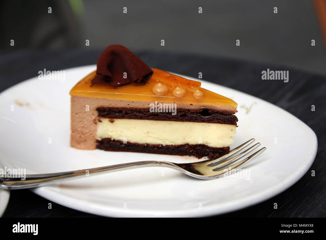 Ein Stück Schokolade orange Mousse Torte auf dem Teller mit Gabel im Cafe Stockfoto