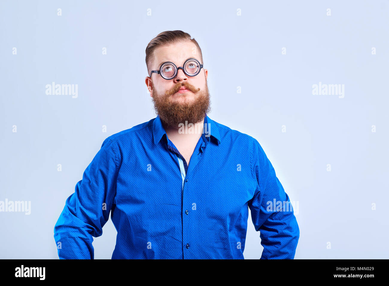 Ein dicker, bärtiger Mann clever mit Brille mit einer gescheiten dumm Ausdr Stockfoto