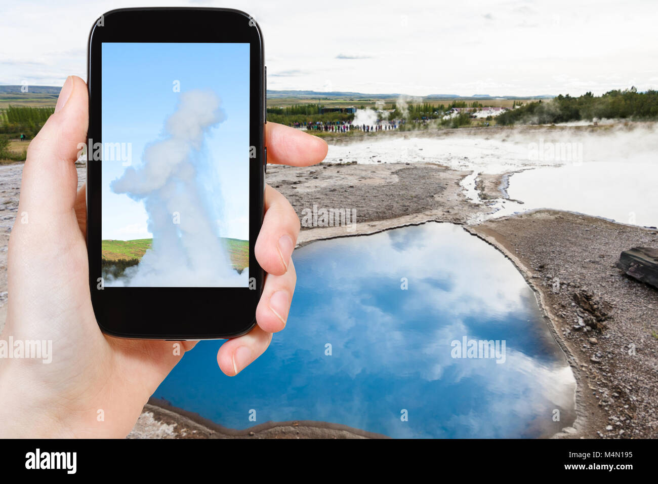 Travel Concept - touristische Fotos pool Der Geisyr (Der Große Geysir) im Haukadalur Hot Spring in Island im September auf dem Smartphone Stockfoto