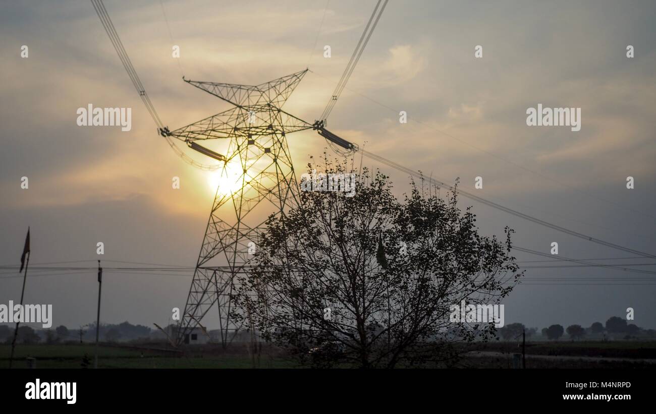 Hoher Strom Spannung Pol mit Sonnenuntergang am Abend. Stockfoto