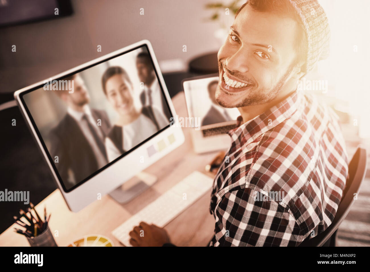 Das zusammengesetzte Bild im Porträt der Mann lächelnd während der Sitzung durch Computer Stockfoto