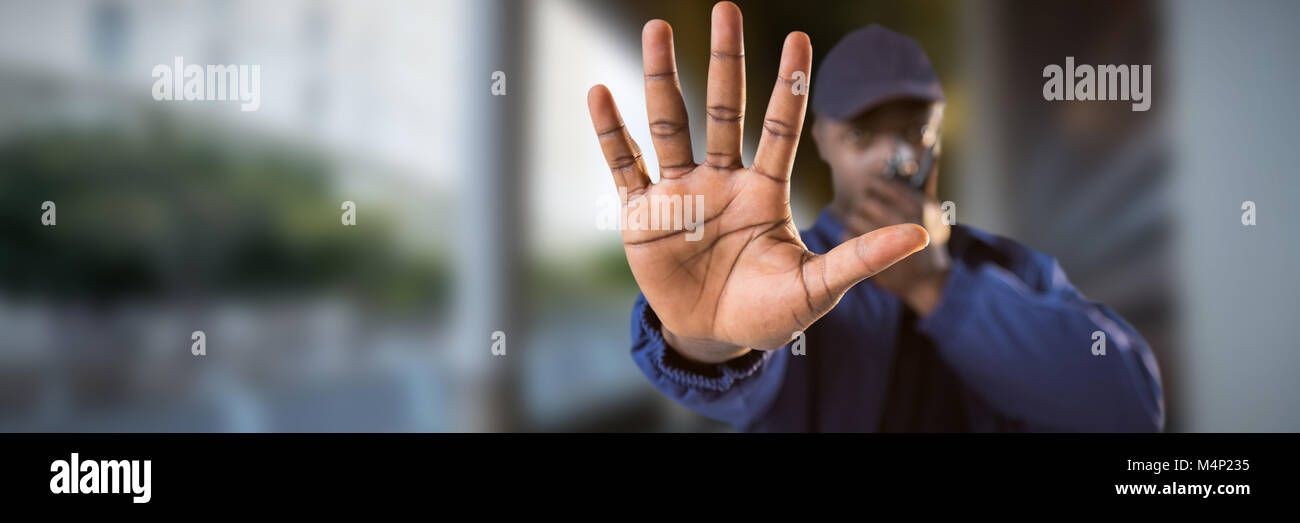 Das zusammengesetzte Bild im zuversichtlich Sicherheit sprechen über Walkie talkie und stop Geste Stockfoto