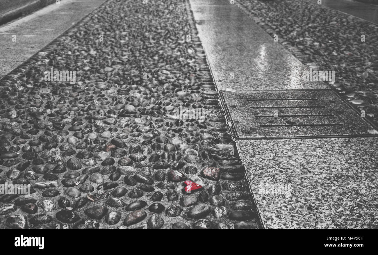 Selektive Farbe der herzförmigen Kiesel auf dem Boden, in Brera, Mailand, Lombardei, Italien erfasst Stockfoto