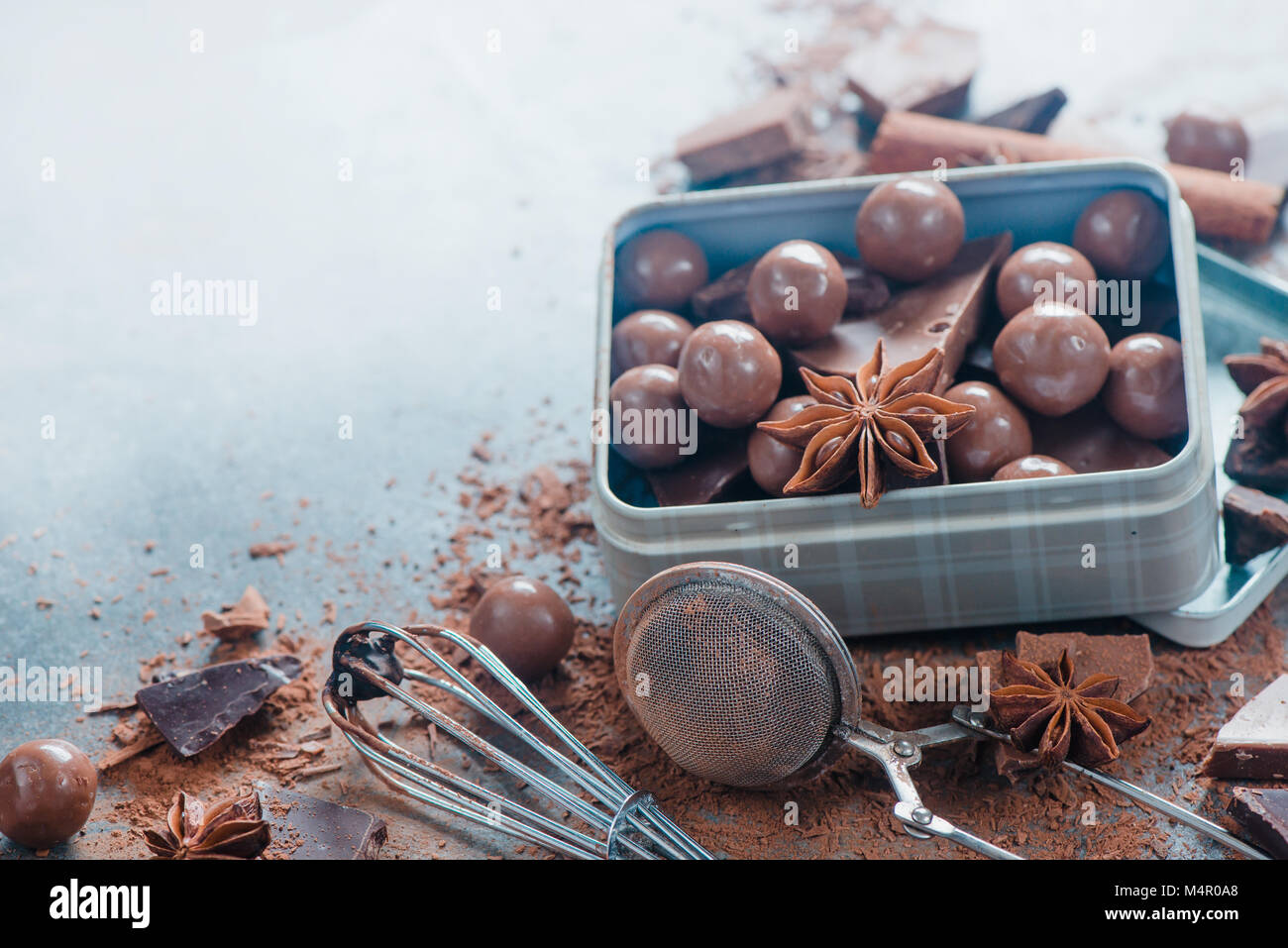 Rustikale Metall mit Pralinen und zerbrochenes Schokolade mit Gewürzen, Anis, Zimt und Kakao auf dem Marmor Hintergrund. Süße Konzept. Stockfoto