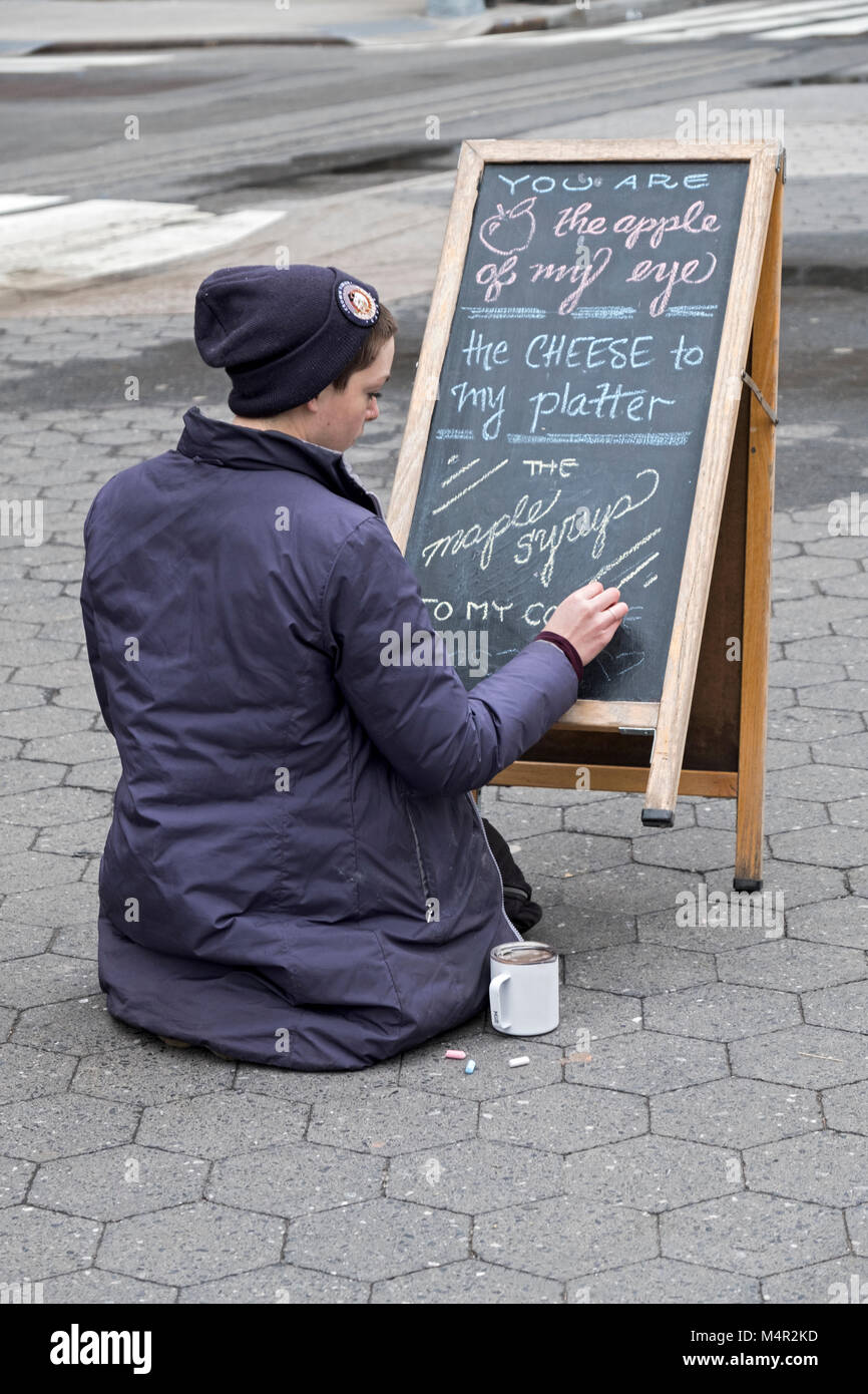 Eine junge Dame in einem wintermantel schreibt ein Zeichen für Bardwell Farm, ein Stand auf der Union Street grünen Markt in Manhattan, New York City. Stockfoto