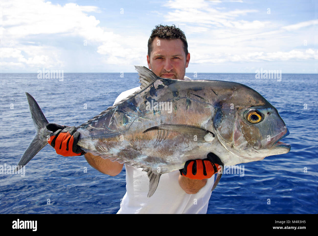 Hochseefischen - glückliche Fischer Holding ein Makrelen jack Stockfoto