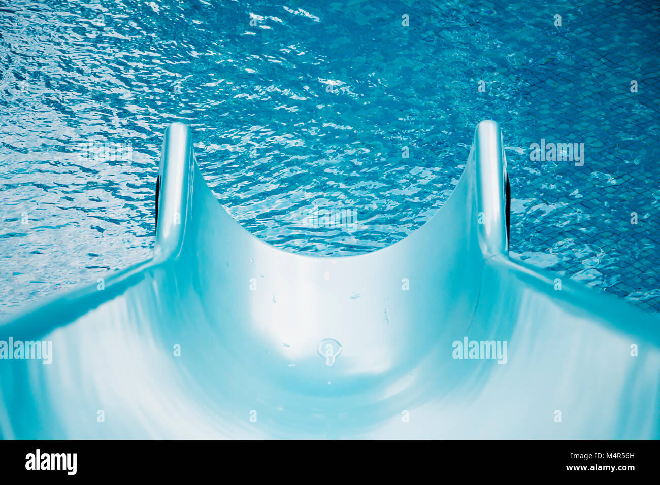 Schöner blauer Swimmingpool und Wasserrutsche mit Wassertropfen für Hintergrund, wellige Wasseroberfläche, hohe Auflösung Stockfoto