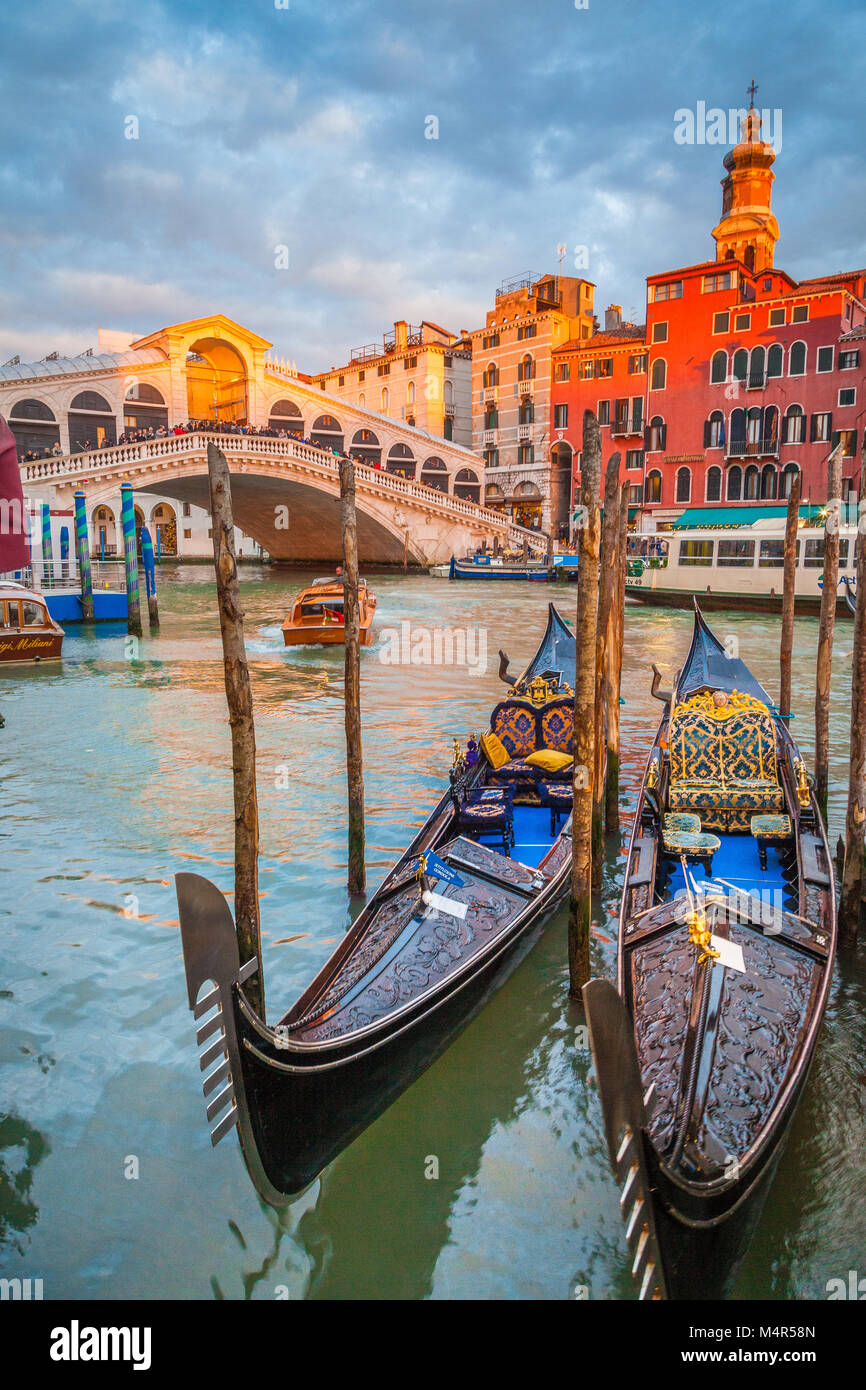 Klassische Panoramablick mit traditionellen Gondeln auf berühmten Canal Grande mit der berühmten Rialto Brücke im Hintergrund in wunderschönen goldenen Abendlicht Stockfoto