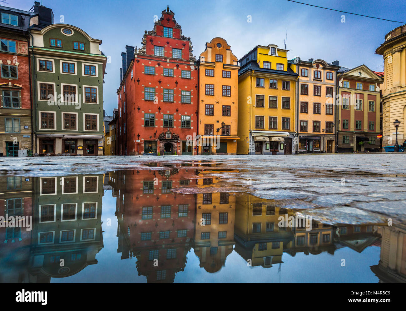 Klassische Ansicht der bunten Häusern an der berühmten stortorget Stadtplatz in der Stockholmer Altstadt Gamla Stan (Altstadt) in einer Pfütze mit blauem Himmel widerspiegelt, c Stockfoto