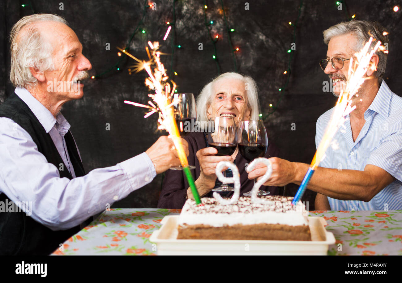 Ältere Leute Toasten mit Alkohol auf eine Geburtstagsfeier Stockfoto