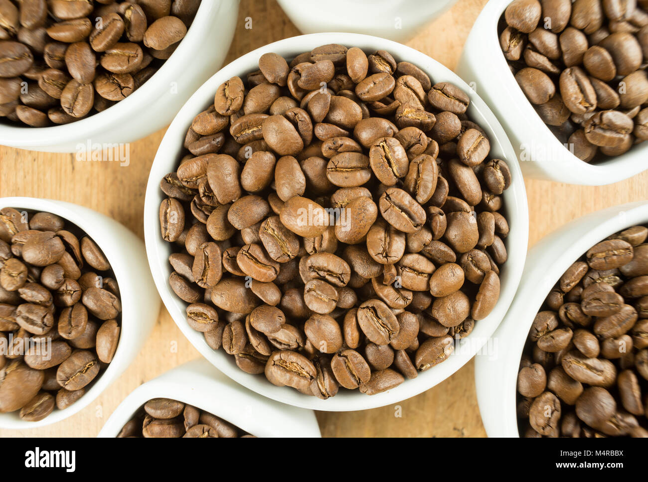 Licht braten braun Kaffeebohnen in weißen Tassen auf einen hölzernen Tisch Stockfoto