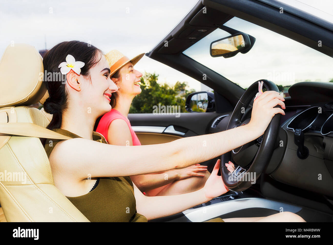 Close-up öffnen Interieur des modernen Luxus sport Roadster mit zwei junge Frau genießen Sie Freiheit und Leben unter freiem Himmel auf einem Sommer sonnigen Tag Stockfoto