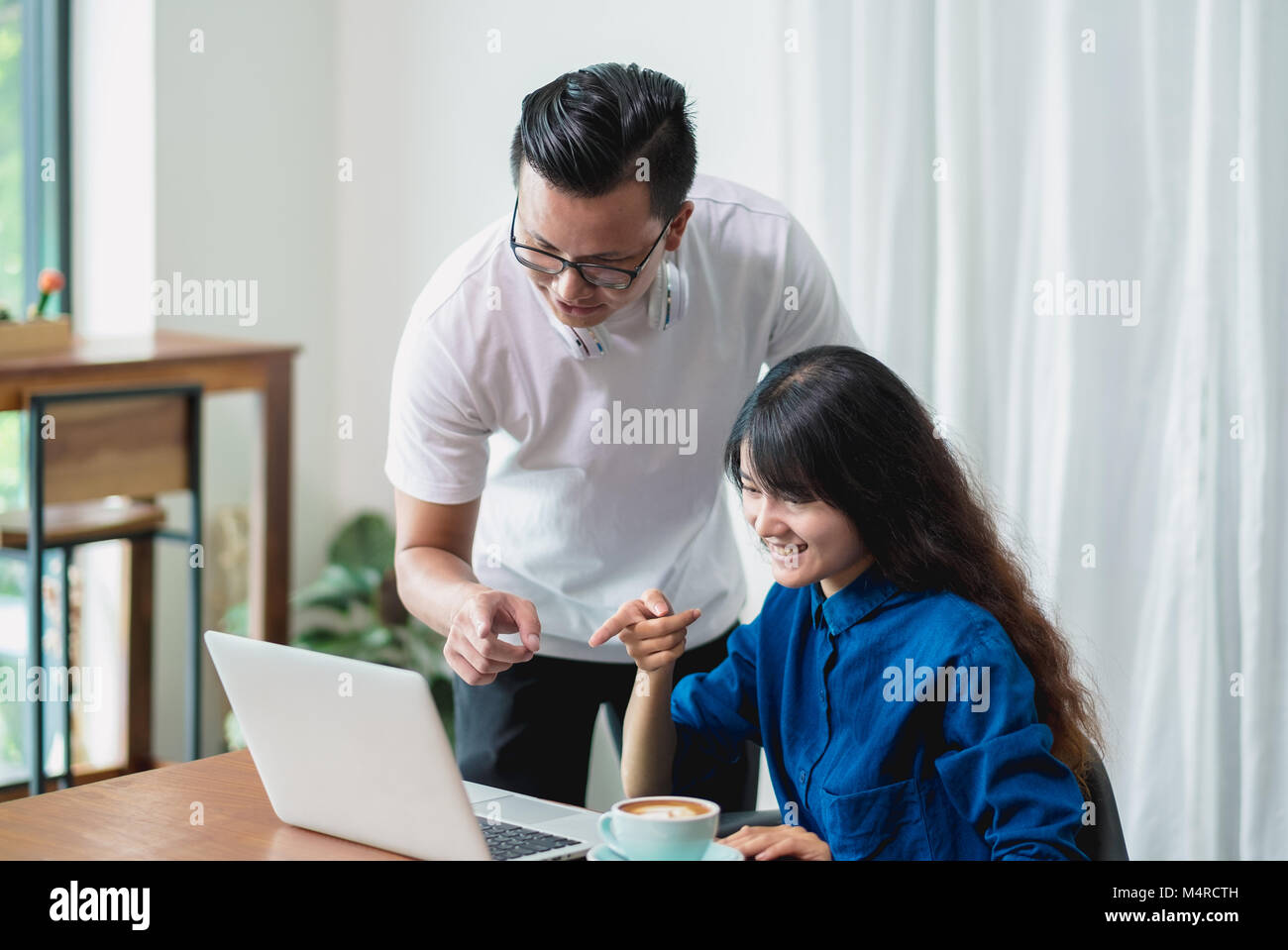 Asiatische Frau und Mann diskutiert mit auf Laptop im Cafe co Arbeitsbereich arbeiten, Digital Lifestyle, Arbeiten außerhalb der Begriff Stockfoto