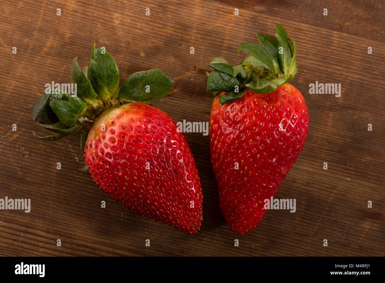 Frische rote Erdbeeren Schuß von Direkt oben im Studio auf braunem Holz- Hintergrund Stockfoto