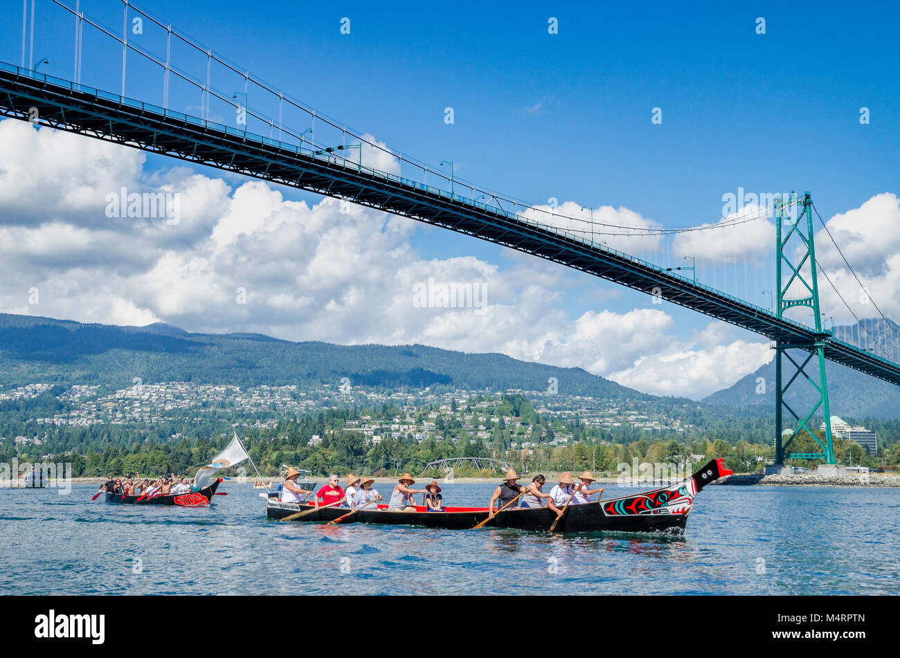Erste Nationen Kanu geht unter die Lions Gate Bridge. Viele Menschen, ein Kanu. Salish ersten Nationen, das Sammeln von Kanus zu den Salish Sea, Septe Schützen Stockfoto