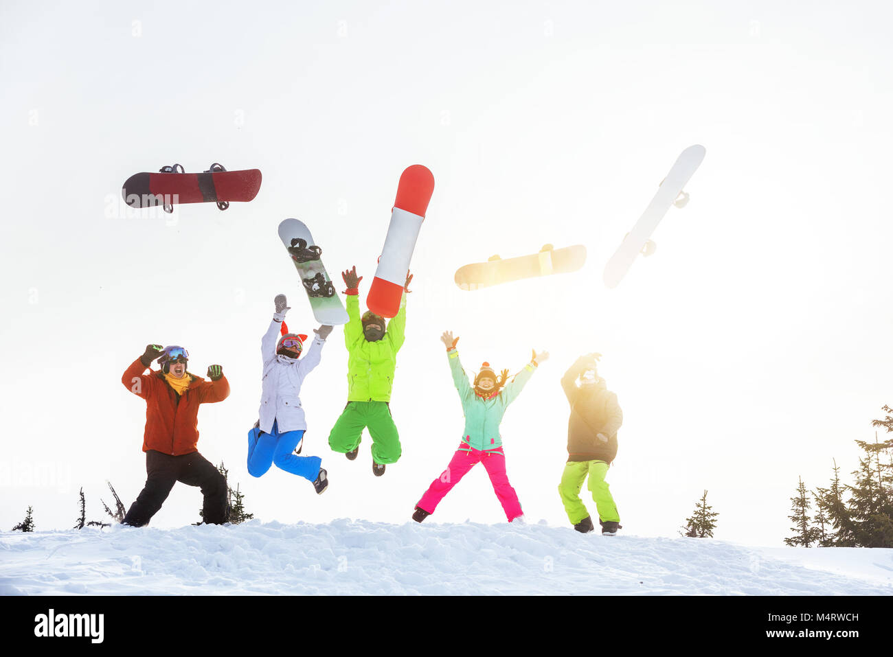Fünf glückliche Freunde Snowboarder springt und Spaß haben Stockfoto