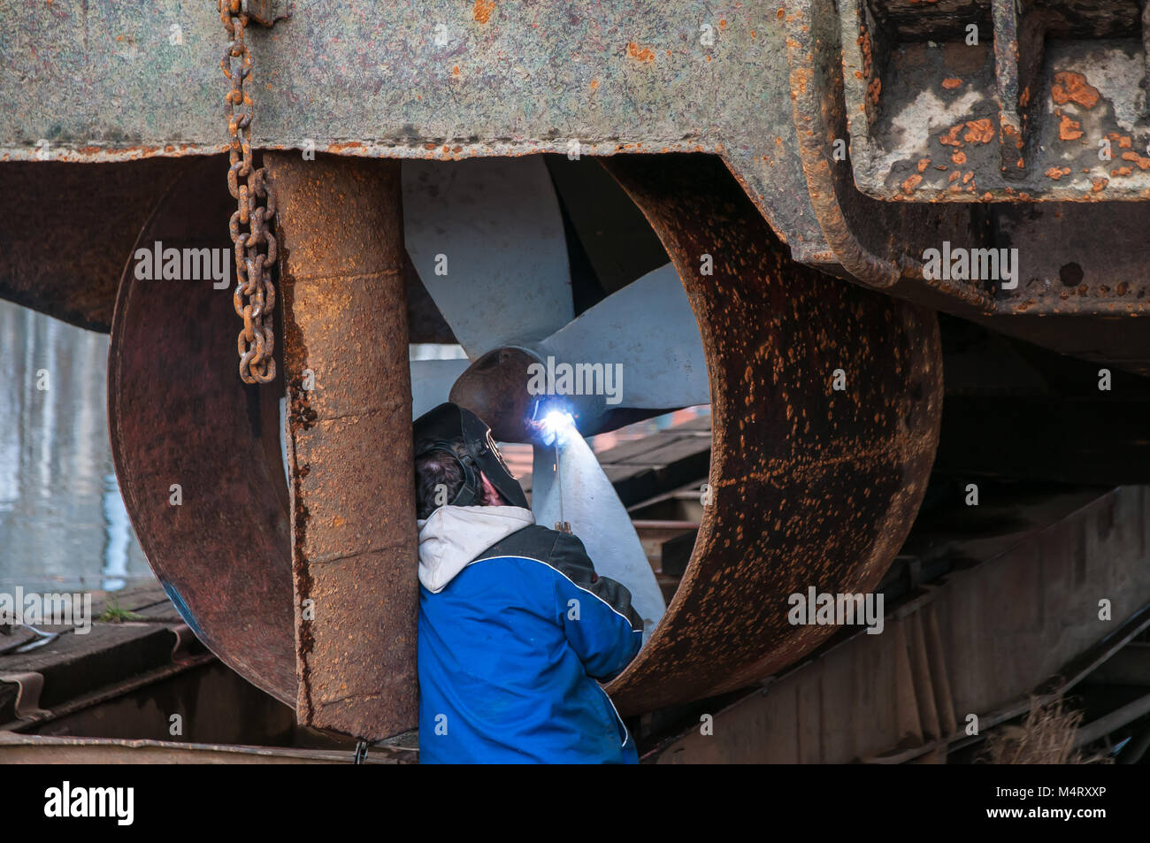 Prag, Tschechische Republik, 12. Februar 2018 Reparatur von Propeller und Düse schieben Schiff auf Trockendock, Mann mit welder Stockfoto