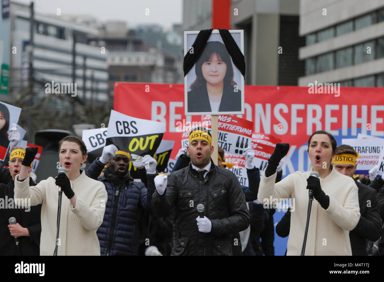 Frankfurt am Main, Deutschland. 17. Februar 2018. Sympathisanten der Vereinigung zum Schutz der Menschenrechte für die erzwungene Konversion singen über Zwangsbekehrungen. Ein Bild von Gu Ji-In, der angeblich während einer erzwungenen Konvertierung starb, ist oben halten. Sympathisanten der Vereinigung zum Schutz der Menschenrechte für die erzwungene (HRAFC) in Frankfurt gegen die angebliche Zwangsbekehrungen durch christliche Hirten, meist im Zusammenhang mit der Christenrat von Korea (CCK), in Südkorea protestierte. Sie wollten das Problem zu markieren und für eine Bestrafung der Täter. Quelle: Michael Debets/Alamy leben Nachrichten Stockfoto