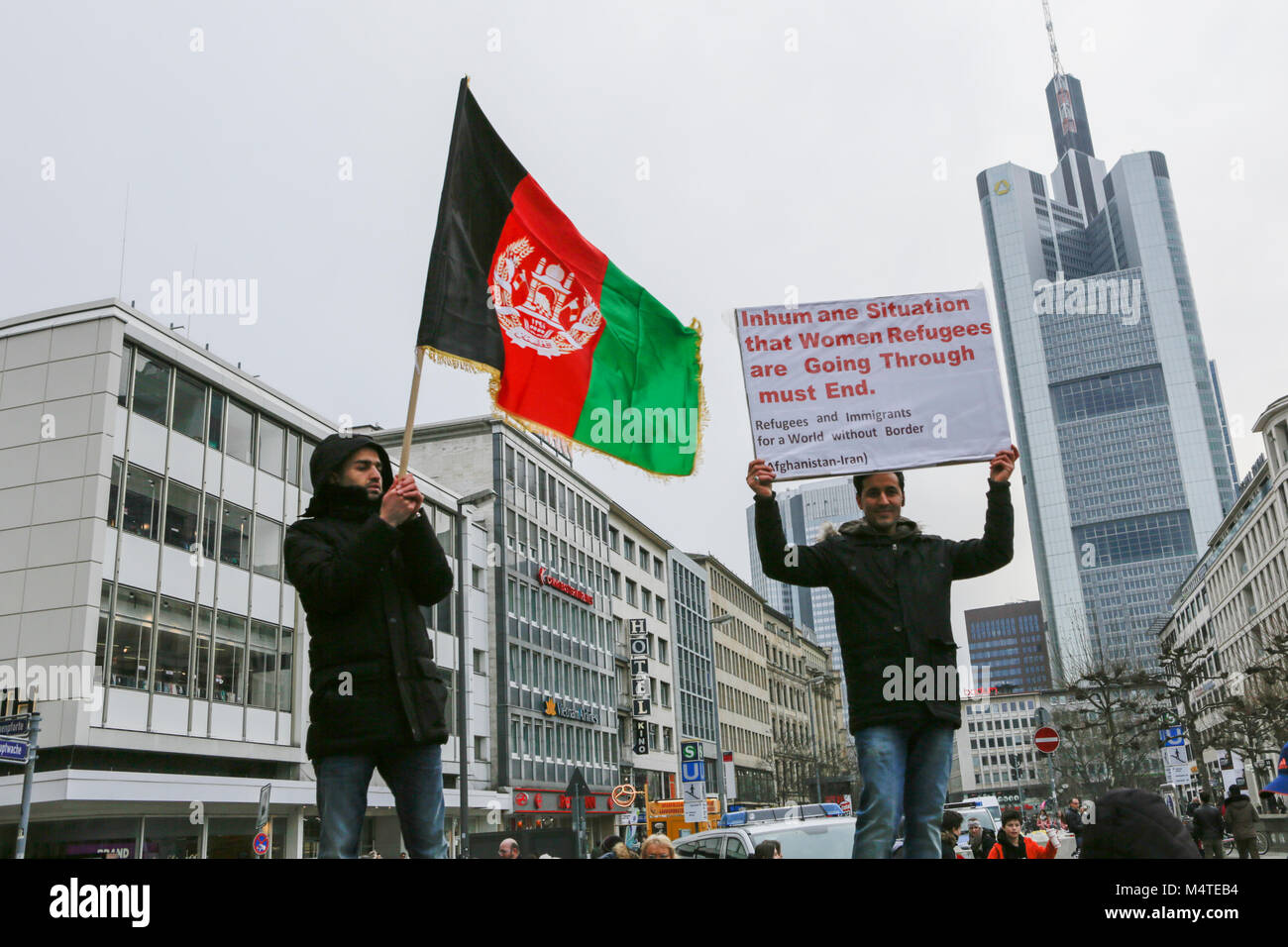 Frankfurt am Main, Deutschland. 17 Feb, 2018. Eine Demonstrantin Wellen eine Flagge des Königreichs Afghanistan, während ein anderer Demonstrant ein Zeichen enthält, wobei die Situation von Flüchtlingsfrauen. Afghanen und Deutschen Unterstützer durch Frankfurt marschierte, für einen Stopp der Abschiebungen nach Afghanistan zu nennen, wie das Land nicht speichern. Sie protestierten auch gegen die aktuelle Präsident Ashraf Ghani und für die Demokratie in Afghanistan genannt. Der Protest war Teil eines europaweiten Tag des Protestes durch die europäischen Bürger gegen Abschiebung nach Afghanistan (Ecada). Quelle: Michael Debets/Pacific Press/Alamy leben Nachrichten Stockfoto