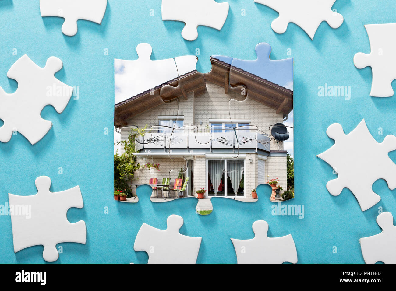 Close-up von unvollständigen Haus Puzzle auf blauem Hintergrund Stockfoto