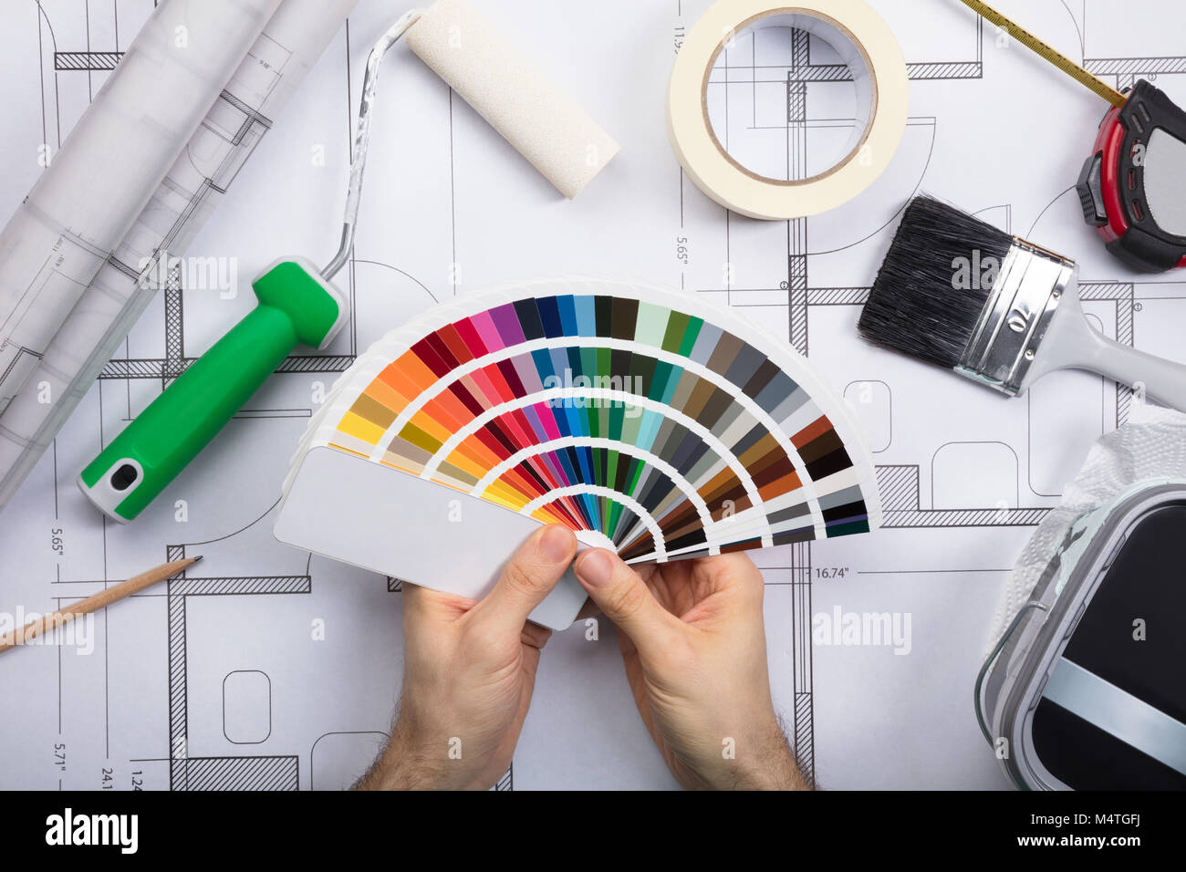Architekt Holding Color Guide Swatch auf Blueprints mit Farbe und Pinsel. Stockfoto