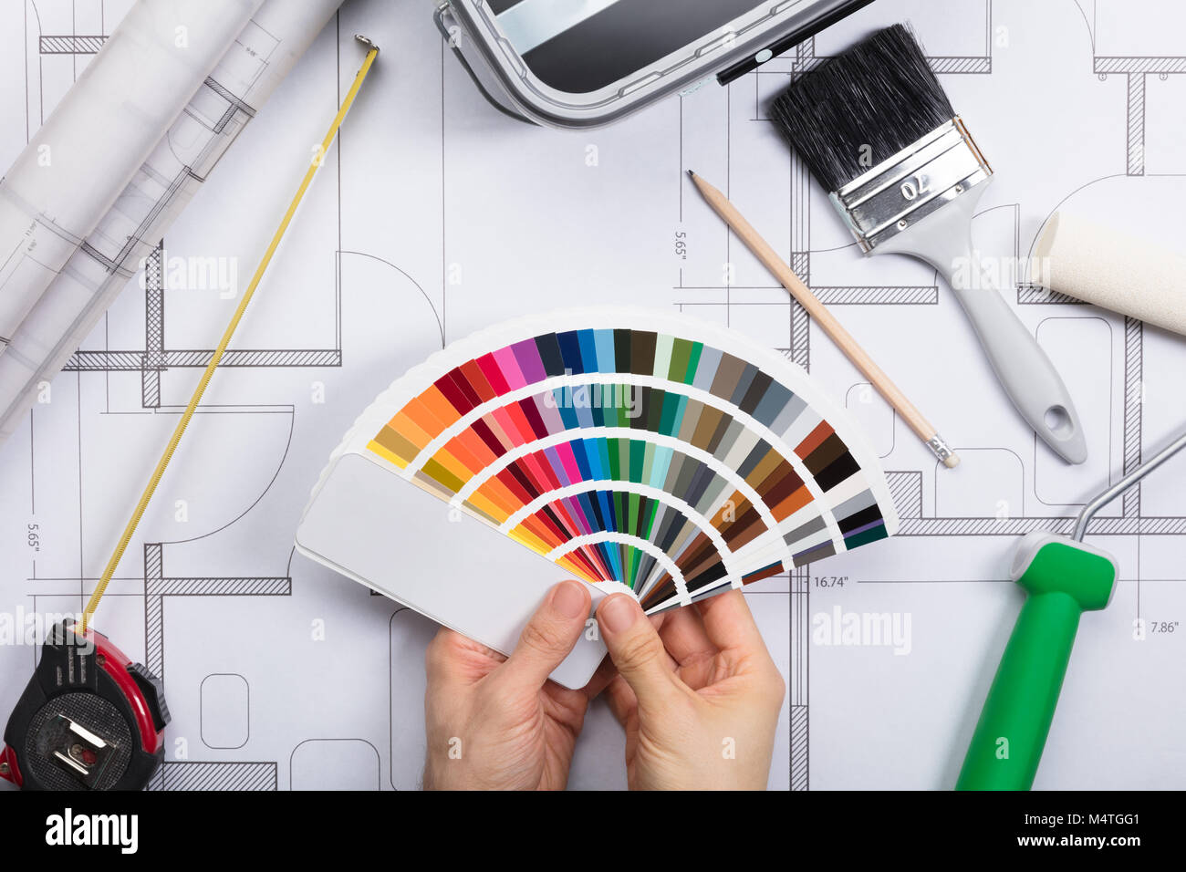 Architekt Holding Color Guide Swatch auf Blueprints mit Farbe und Pinsel. Stockfoto