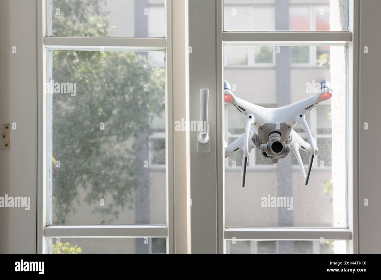 Fliegen weiß Quadrocopter Bespitzelung durch das Fenster eines Hauses Stockfoto