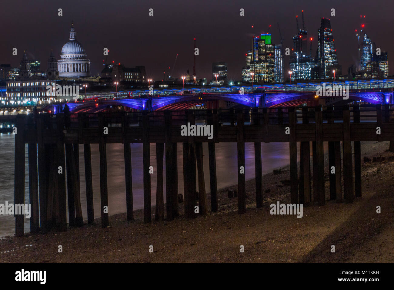 Ebbe und ein Pier am Ufer des South Bank mit St Paul's Kathedrale im Hintergrund ausgesetzt. Stockfoto