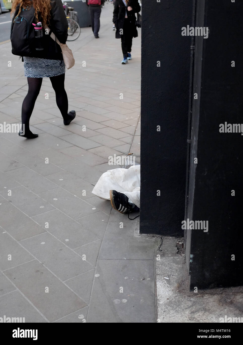 Brighton UK Februar 2018 - Obdachlose Menschen schlafen in North Street Shop Eingang mit Füßen heraus haften auf Pflaster Stockfoto