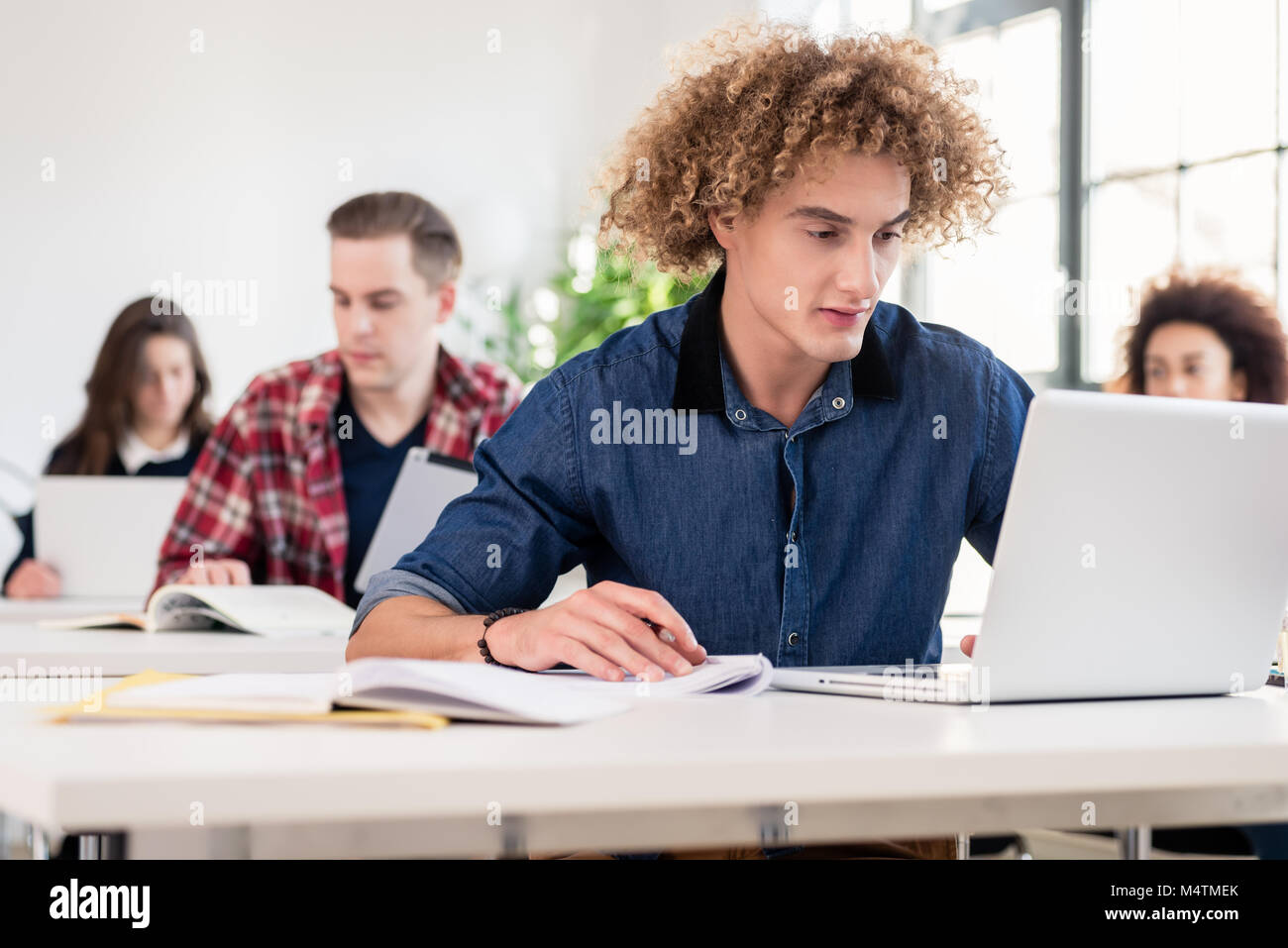 Portrait einer jungen hart arbeitenden Studenten schreiben während Klasse Stockfoto