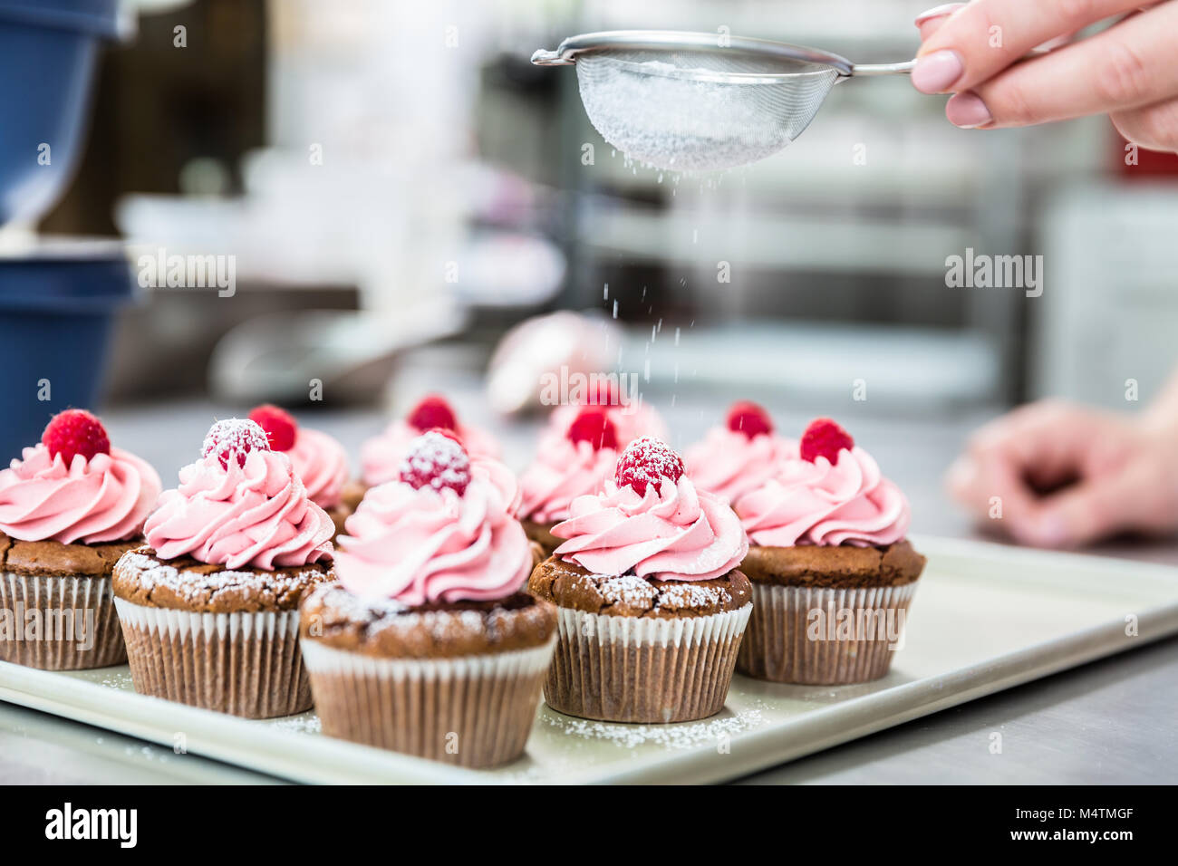 Frau in Süßwaren Vereisung Cupcakes mit Zucker Stockfoto
